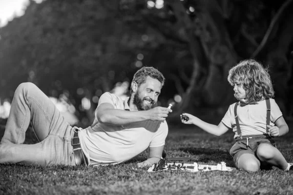 父と息子のチェスを一緒に屋外で過ごす時間を過ごす。チェスゲームのような男。男性像. — ストック写真