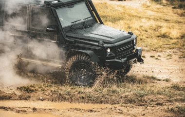 Dağ yolunda SUV 'un önü alçak açılı. Ormandaki aşırı off-road turu. Dağ yolunda off-road arabası.