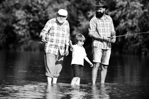 Pesca. Fin de semana. Padre e hijo pescando. Pesca en el río. Tres generaciones de edad: abuelo, padre e hijo adolescente. Feliz día de los padres . — Foto de Stock
