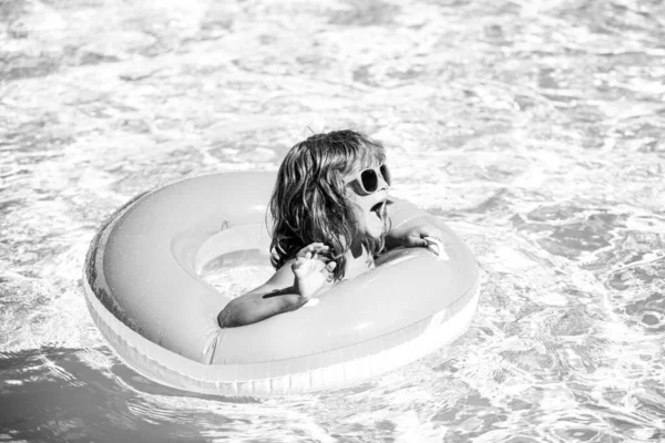 Aquapark vacaciones de verano. Un chico en la piscina. Niño feliz en círculo de goma inflable. — Foto de Stock