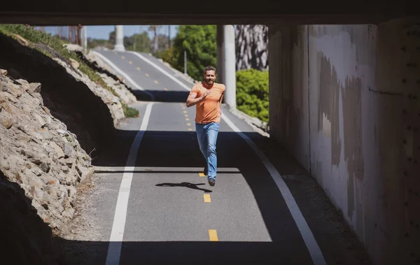 Comprimento total de homem saudável correndo e sprint ao ar livre. Jovem fitness esporte masculino corredor correndo na estrada da cidade. — Fotografia de Stock