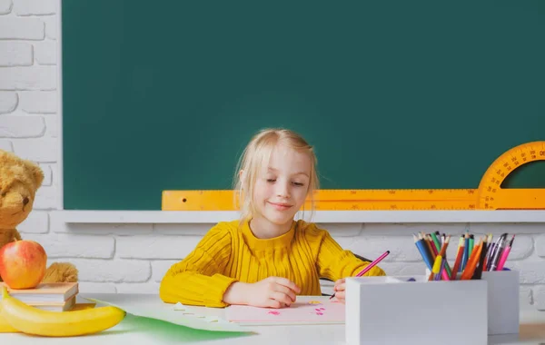 かわいい小学生の女の子は教室で勉強します。教育、学習、子供の概念. — ストック写真