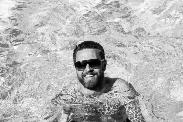 Un bel homme aux lunettes de soleil. Vacances d'été. Fête de piscine. Station estivale. — Photo