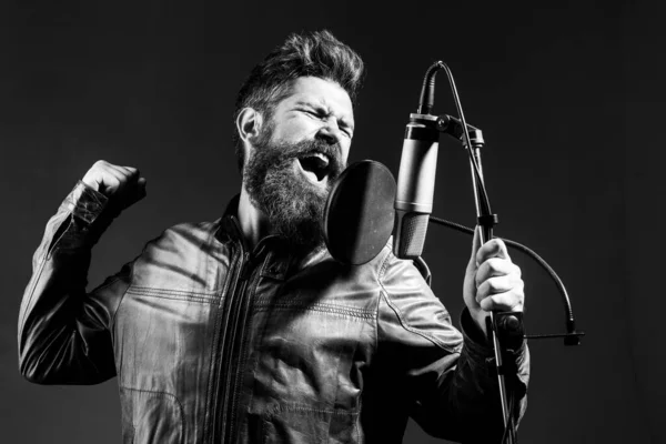 Muž s mikrofonem zpívající píseň. Hudebník v hudebním sále. Výrazná zpěvačka s mikrofonem. Vtipálek zpívající v karaoke. — Stock fotografie