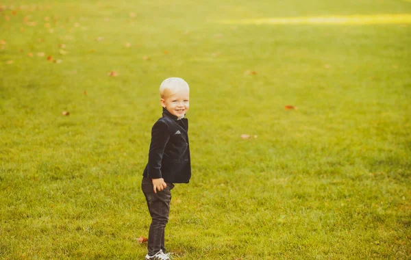 Ragazzo primaverile sul prato. Buona infanzia. Bambino ragazzo ritratto soleggiato. — Foto Stock