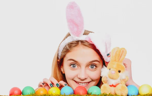 Caza de huevos. Chica en conejo de Pascua orejas de conejo con huevos. Mujer mirando por encima de una superficie. —  Fotos de Stock