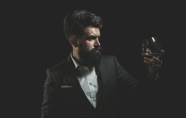 Picie whisky, brandy lub koniaku. Elegancki i stylowy mężczyzna w klasycznym ubraniu trzymający szkło z wiskey w ręku. Stylowy bogaty człowiek trzymający szklankę starej whisky. — Zdjęcie stockowe
