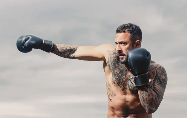 Boxe de pontapé muscular ou muay thai lutador de perfuração. Lutador de kickboxing em luvas de boxe batendo sombra, treinando para competição. Soco de boxe. — Fotografia de Stock