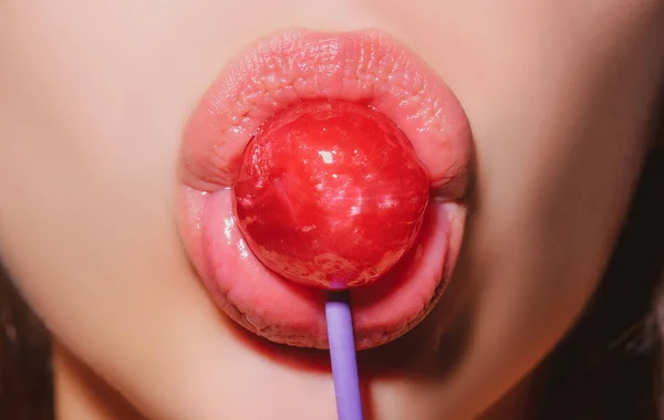 Chupando labios. Sexy lollipop lamiendo la boca, labios brillantes femeninos rojos y caramelo rosa lollipop. — Foto de Stock