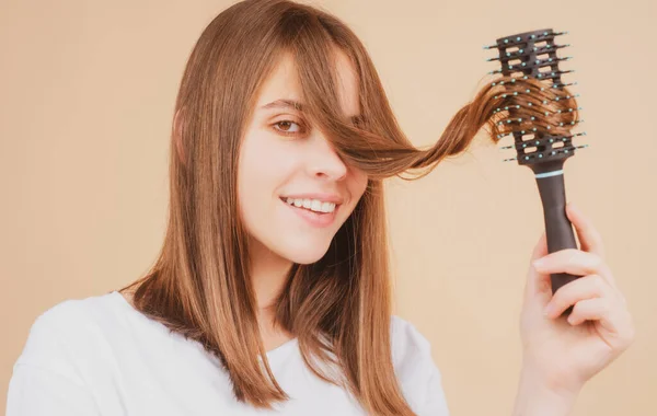 若い美しい女性は茶色の髪を持っています。ヘアケア。ヘアブラシ付きの美しいブルネットの女性のヘアブラッシング髪。櫛で健康な髪を磨く. — ストック写真