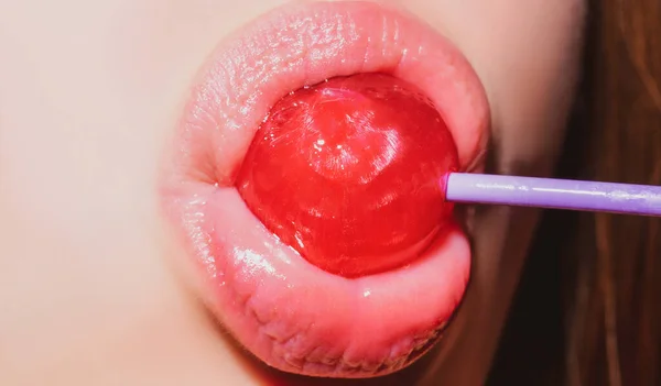 Şeker yalıyorum. Lolipop modeli. Kadın dudakları şeker emiyor. Kırmızı dudaklı çekici manken eşofman altı yiyor lolipop. — Stok fotoğraf