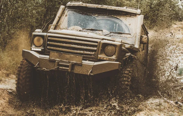 Modder en water spatten in off-road racen. Offroad voertuig komt uit een moddergat gevaar. Slepen raceauto brandt rubber. Extreem. Off-road auto. Rally racen. — Stockfoto