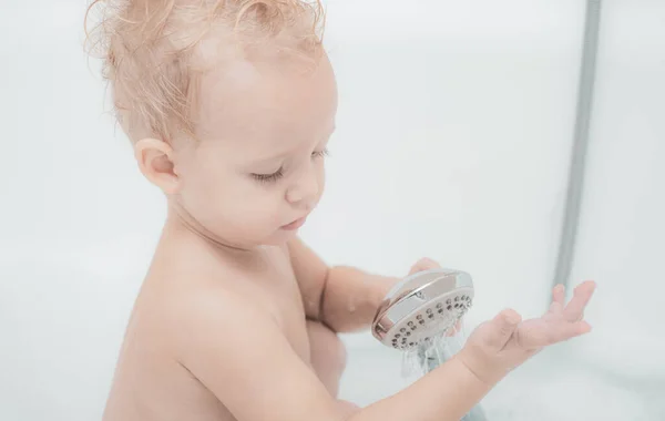 婴儿在浴缸里快乐的幼儿婴儿洗澡玩妈妈和泡沫。婴儿在白色浴缸中洗澡. — 图库照片