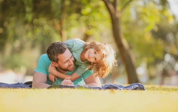 Kindheits- und Elternschaftskindkonzept. Glücklicher Vater und Sohn spielen zusammen im Freien. — Stockfoto