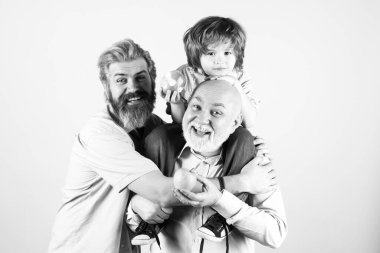 Baba, oğul ve büyükbaba mutlu bir aile. Mutlu yıllar, çok nesilli erkekler. Büyükbaba baba baba ve çocuk torun sarılıyor ve gülümsüyor..