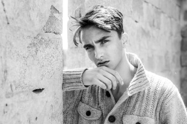 Genç adam kameraya bakıyor. Dışarıdaki yakışıklı adam..