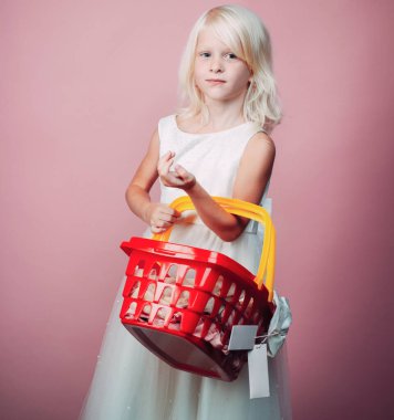Çocuk plastik alışveriş sepeti oyuncak tutun. Çocuk mağazası. Alışveriş merkezi alışverişi. Ürün satın alın. Mağaza oyunu oynayın. Sevimli alıcı müşteri müşteri alışveriş sepeti tutun. İndirimli satın alın. Kız sevimli sarışın çocuk alışveriş