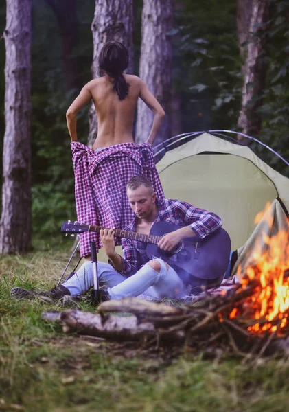 Loving young coupl near camp tent. Camping couple in love. Couples of lovers tourists relax on nature. Camping trip with lovers. Picnic for friends tourists. — Stock Photo © Tverdohlib.com #566608950