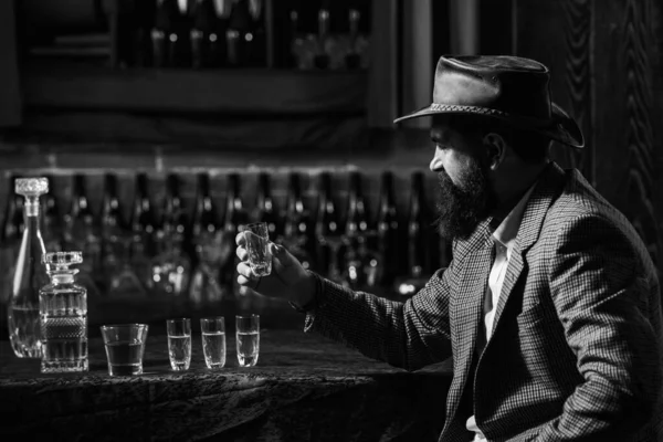 Un caballero barbudo bebe coñac. Guapo hombre estresado sosteniendo un vaso de whisky. —  Fotos de Stock