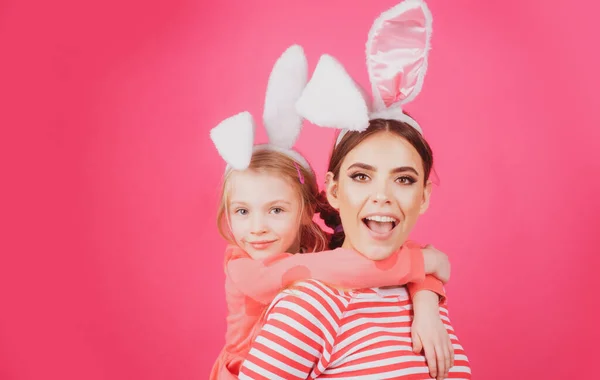 Ragazze amiche felice Pasqua. Concetto infanzia felice. Piccola sorella femmina coniglietto orecchie isolato su sfondo rosa. — Foto Stock