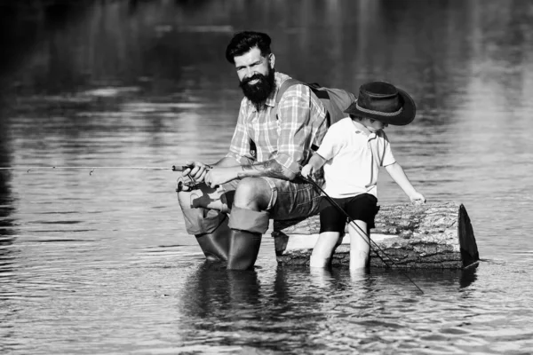 Pai e filho a pescar juntos. Ele gosta de falar com o pai. Conceito de idade de reforma. Feliz pai e filho pesca no rio segurando varas de pesca . — Fotografia de Stock