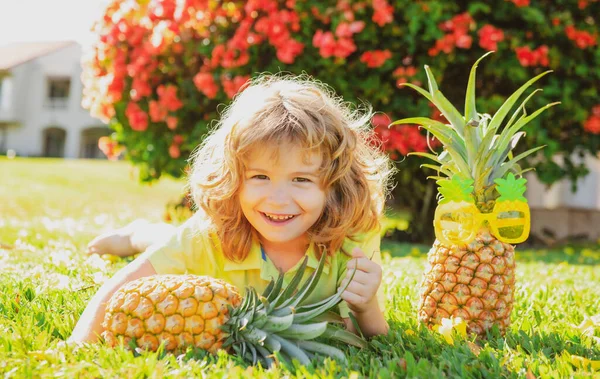 Miúdo giro com abacaxi. Frutas tropicais frescas para crianças. Estilo de vida saudável com frutas orgânicas frescas. — Fotografia de Stock