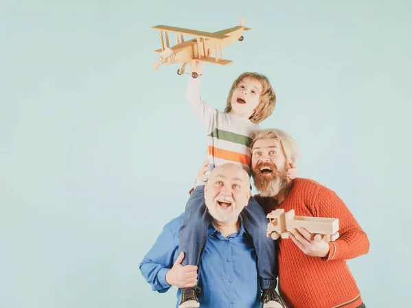 Tres generaciones diferentes edades abuelo padre e hijo hijo jugando con avión de juguete en el estudio. Viaje viaje concepto de viaje. Fondo aislado. Aventura familiar, inspiración para la innovación. — Foto de Stock