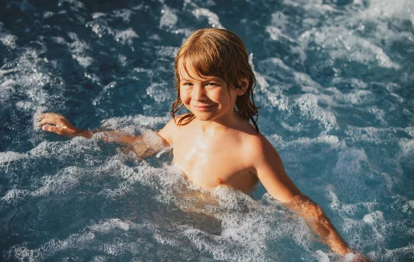 Tatlı çocuk havuzda yüzüyor. Aktif sağlıklı çocuklar için yaşam tarzı, su sporları aktiviteleri ve çocuklarla yaz tatili dersleri..