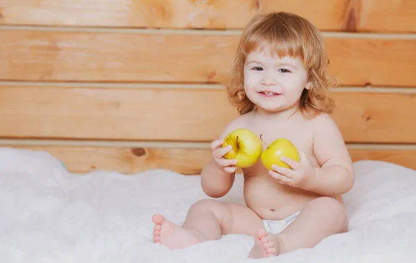 可爱的微笑的婴儿吃苹果.小男孩在吃苹果。有新鲜水果的小孩. — 图库照片
