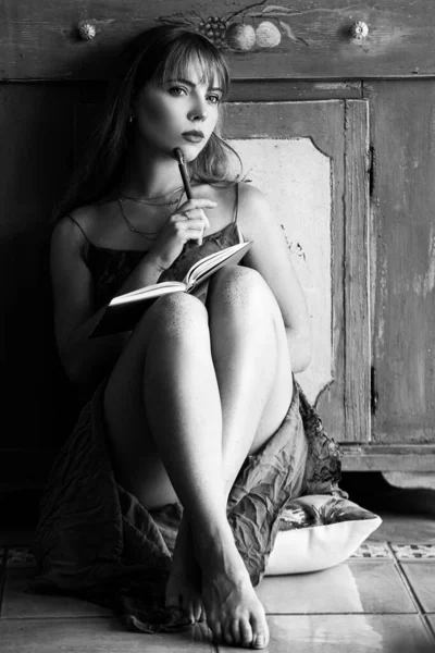 Pensamento feminino pensativo sobre ideias sentadas com livro. Uma jovem sonhadora a olhar. Pensando menina ruiva sonhando olhando para cima. Conceito de sonho. Menina fazendo anotações em notebook em casa . — Fotografia de Stock
