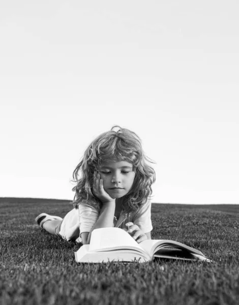子供読書本で公園で緑の芝生. — ストック写真
