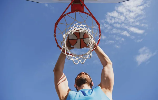 Närbild av professionell basketspelare gör slam dunk under basketmatch i utomhus basketplan. — Stockfoto