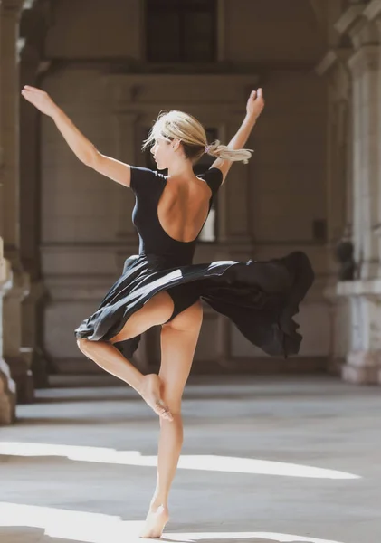Street-Style-Foto von eleganten modischen Frauenbewegung im Rock. Sexy schwarzes Kleid. Sinnliche Frau tanzt draußen, Ballerina tanzt im schwarzen Kleid. — Stockfoto