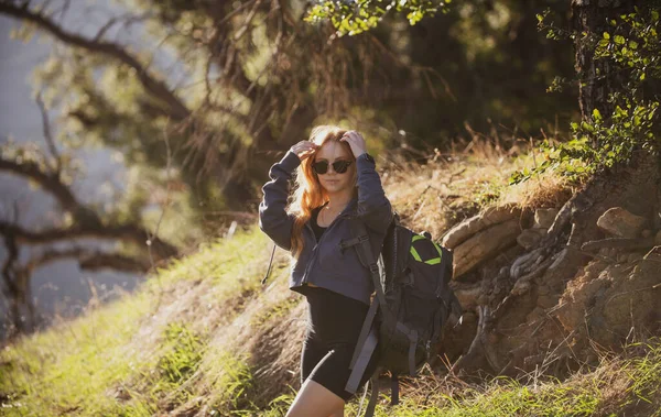 Senderista femenina con mochila en la montaña. Niña caminando una colina en el punto panorámico. Concepto de turismo mochilero. — Foto de Stock