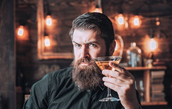 Retro-Bar. bärtiger Mann sitzt an der Bar. schöner Mann trinkt Alkohol, während er an der Bar sitzt. — Stockfoto