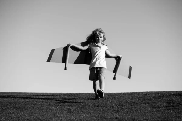 Милый мечтатель мальчик играет с картонным самолетом на небе. Детство. фантазия, воображение. — стоковое фото