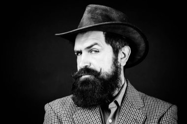 Geçmişi olan yakışıklı bir adam, siyah arka planda ciddi sakallı bir hippinin portresi..