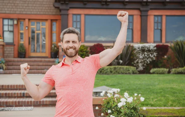 Lächelnder Immobilienmakler in der Nähe eines neuen Wohnsitzes zum Verkauf, draußen. Mieten Sie ein neues Zuhause. Erstaunlich aufgeregter Geschäftsmann. — Stockfoto