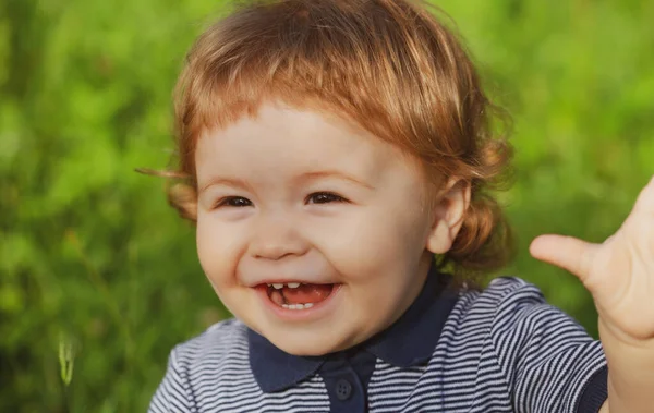 Portret van een leuke jongen die plezier heeft in de tuin. Baby gezicht van dichtbij. Grappig kinderportret. Blond kind, emotie gezicht. Gelukkige kindertijd en baby gezondheidszorg. — Stockfoto