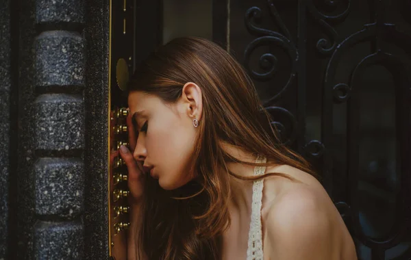 Depresyondaki üzgün kadın. Kendini soyutlama. Ev güvenliği kavramı. Kadın dahili iletişim kodu düğmesi. Bayan kadın kapı zili bina girişinde..