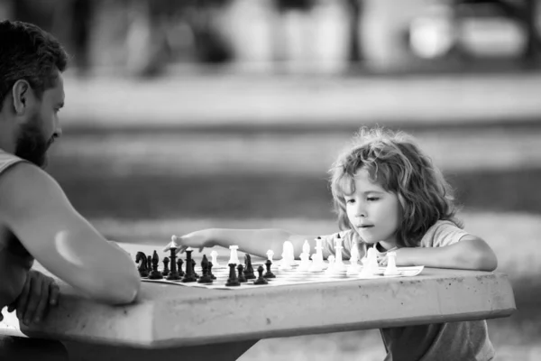 Vater und Sohn spielen Schach und verbringen die Zeit zusammen im Freien. Spiele und Aktivitäten für Kinder. — Stockfoto
