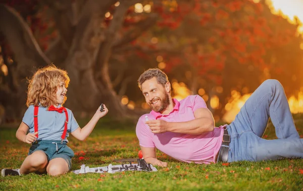 Baba oğluyla satranç oynar. Aile oyunu dışında. Akıllı çocuk, akıllı çocuklar..