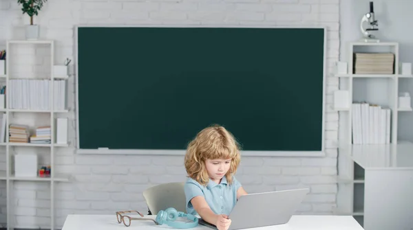 Pojke student lärande online i klassen. Kid studera online videosamtal med zoom. Elever lär sig engelska på nätet med bärbar dator i skolan. — Stockfoto