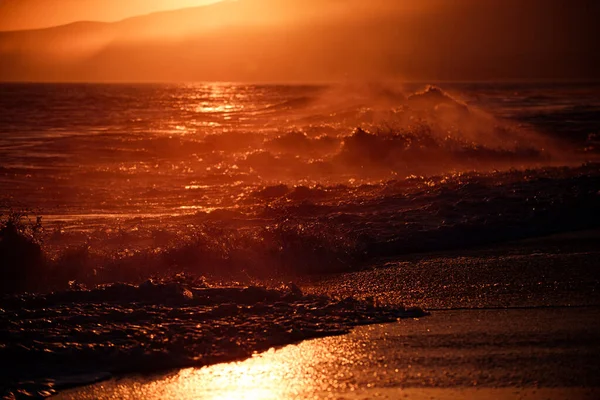 Nascer do sol sobre o mar tropical. Pôr do sol colorido com salpicos de onda na praia. — Fotografia de Stock