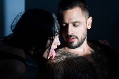 Bir çift genç aşık. Çekici bir çift ve stüdyo arka planında çıplak kaslı bir adam. Birbirine aşık bir çift. Güzel genç aşıklar.