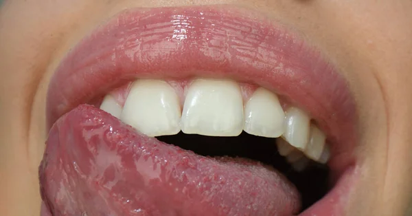 Concepto de expresión de boca belleza. Primer plano de cara de mujer con lápiz labial rojo lamiéndose los labios con lengua sensual. —  Fotos de Stock