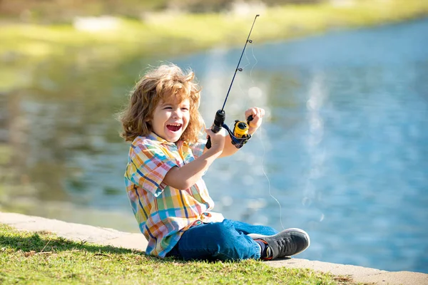 Porträt eines aufgeregten Jungen beim Angeln. Aufgeregt überraschter Junge sitzt am See und angelt. — Stockfoto