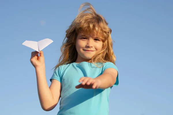 折り紙紙飛行機。青い空の背景を持つ紙飛行機を投げる子供の男の子. — ストック写真