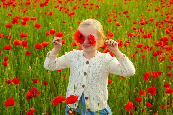 Chica con ojos de amapolas. Prado de amapolas con flores de amapolas. Hermosa niña caminando en el campo de flores de amapola de primavera. Primavera al aire libre niños. —  Fotos de Stock