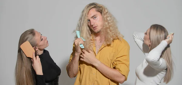 Group portrait of young people combing hair. Прическа, уход за волосами. Групповая расческа волос щеткой. Женщина-портрет и мужчина расчесывают длинные здоровые волосы щеткой для волос. — стоковое фото